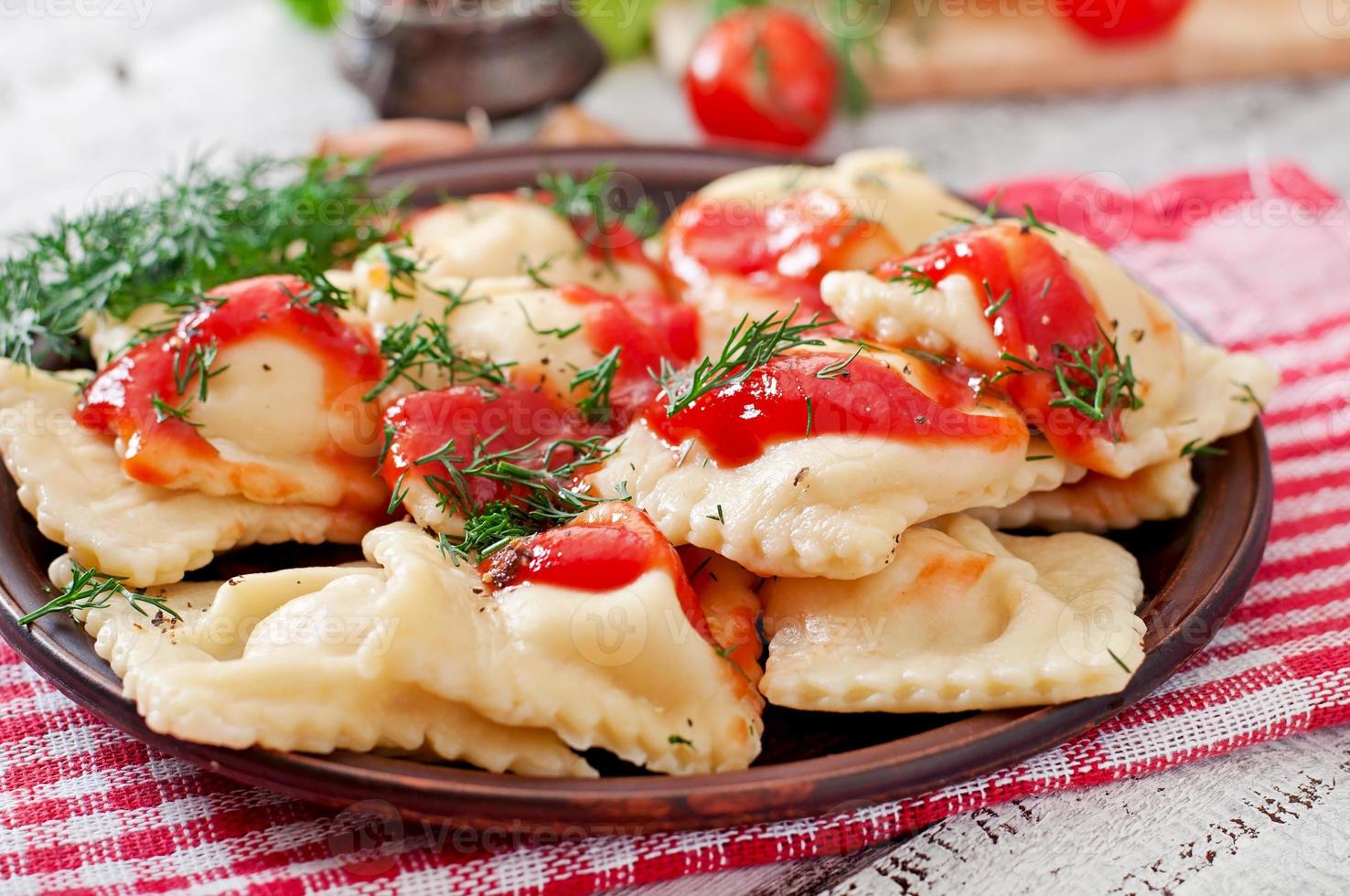 Delicious ravioli with tomato sauce and dill photo