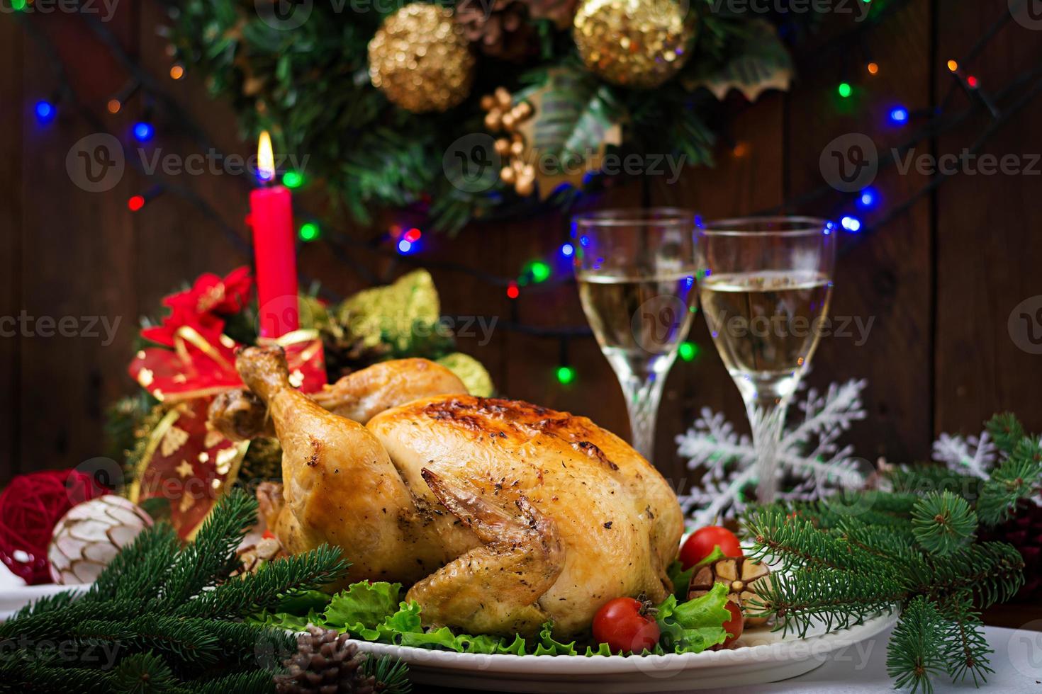 Baked turkey or chicken. The Christmas table is served with a turkey, decorated with bright tinsel and candles. Fried chicken, table. Christmas dinner. photo