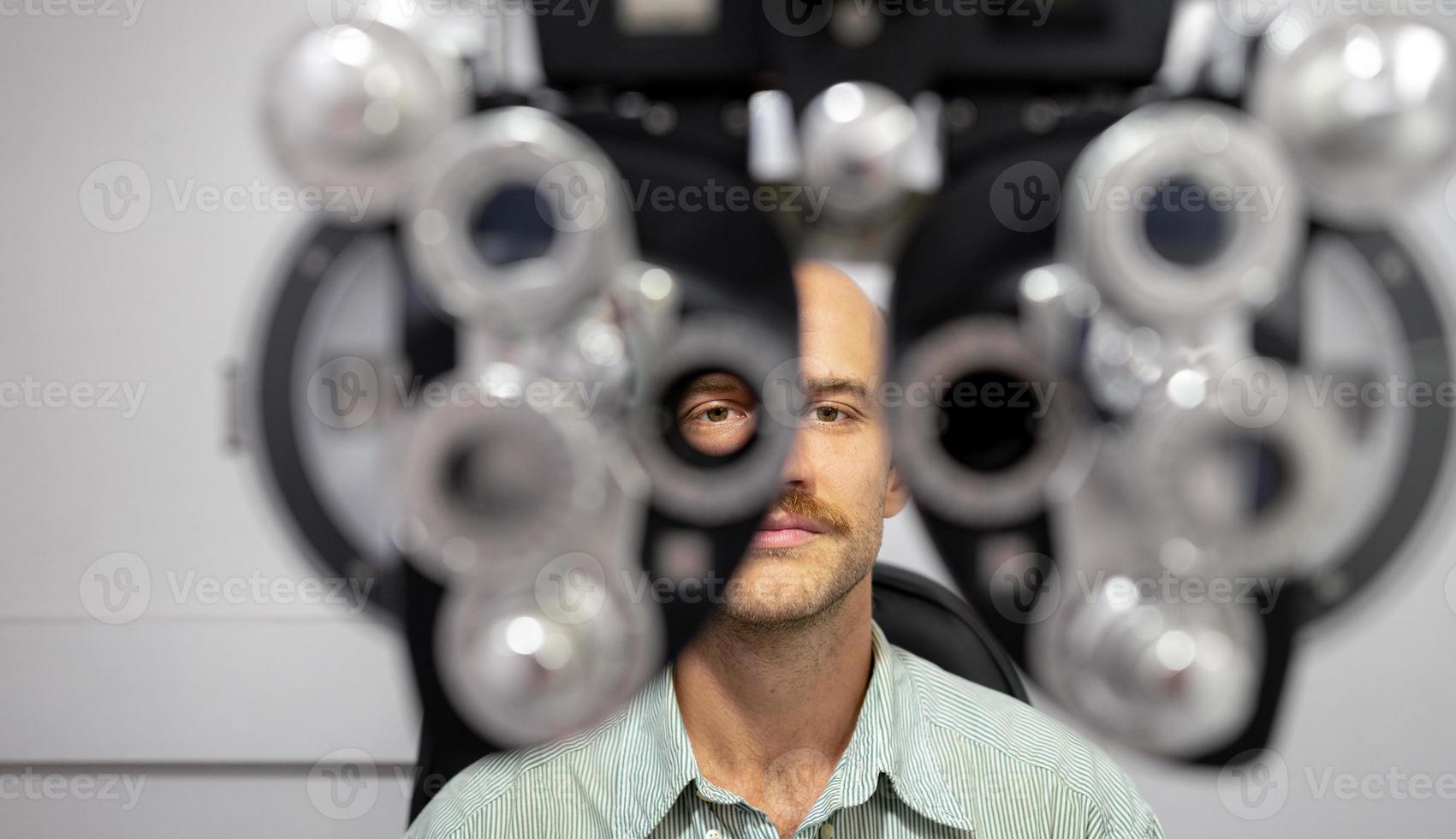 Young man checking his eyes to make glasses. photo
