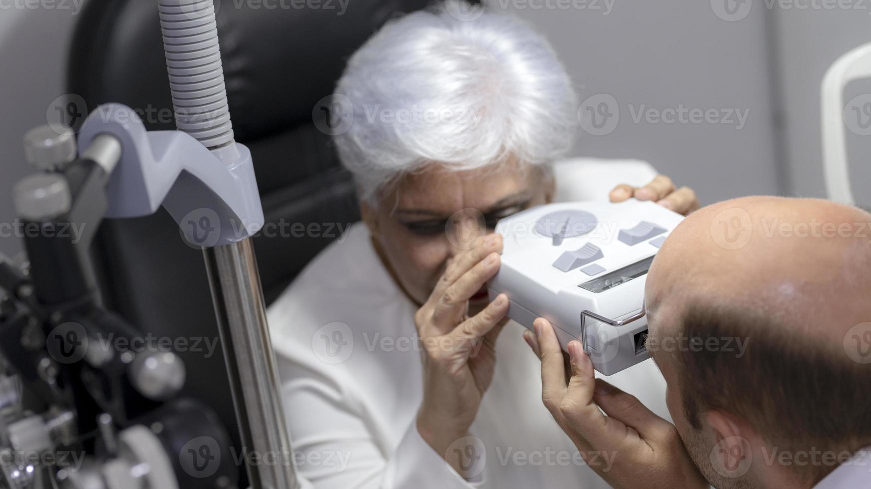 Elderly women have their eyes examined by an ophthalmologist. photo