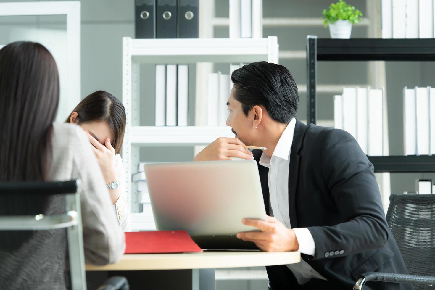 A group of young Asian entrepreneurs. Top Management is meeting to review stock investment data from the team in a meeting room with natural light photo