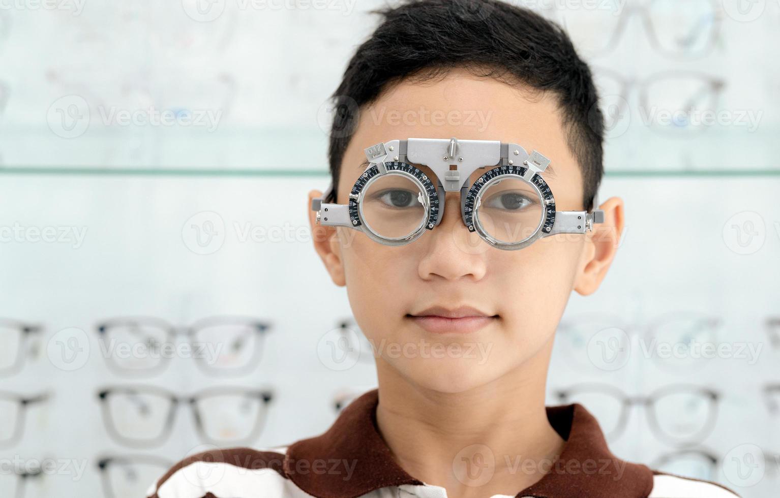Boy has his eyes checked for glasses by a specialist. photo