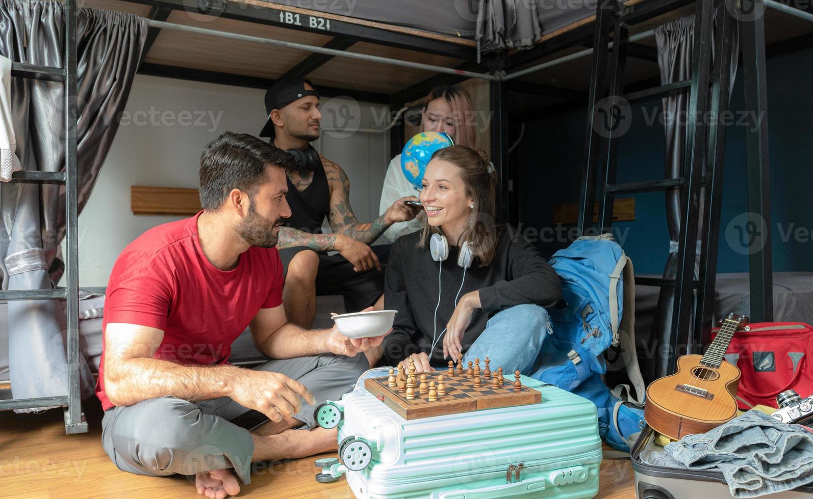 Groups of travelers of different nationalities having fun in the hostel. photo
