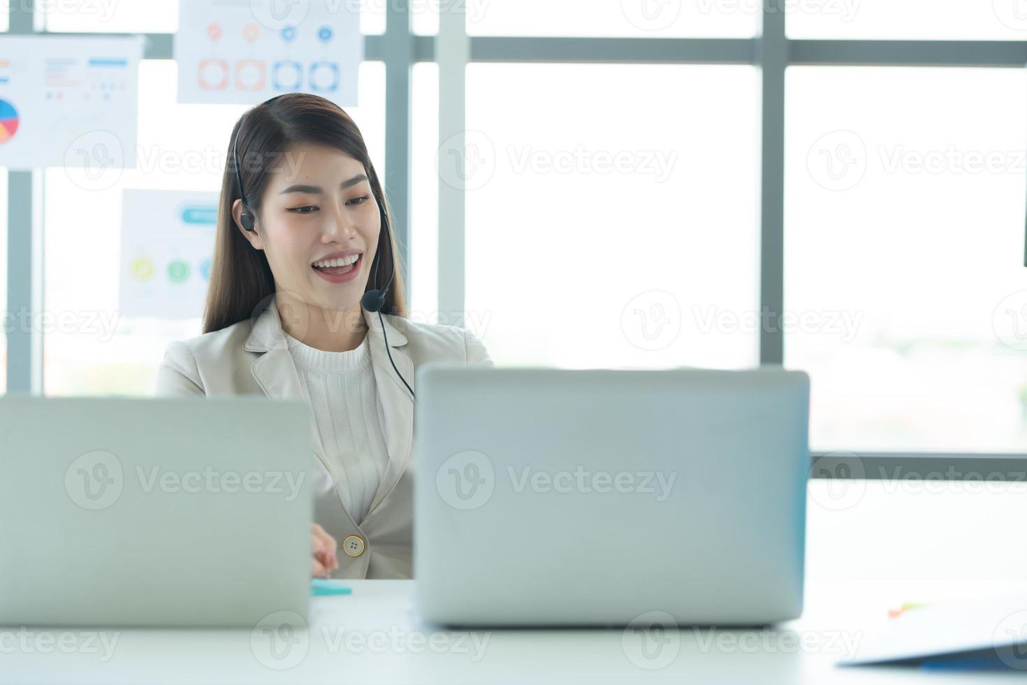 Young asian woman working at a call center Consulting about stock investment information with customers calling for advice photo