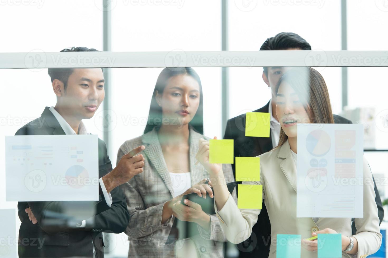 Young entrepreneurs in Asia Organize meetings to brainstorm and review information on glass board photo