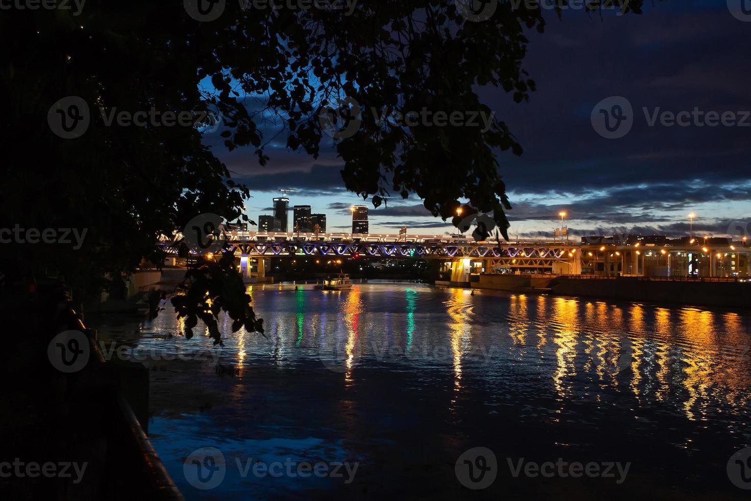 vista nocturna del río y el puente sobre él. foto