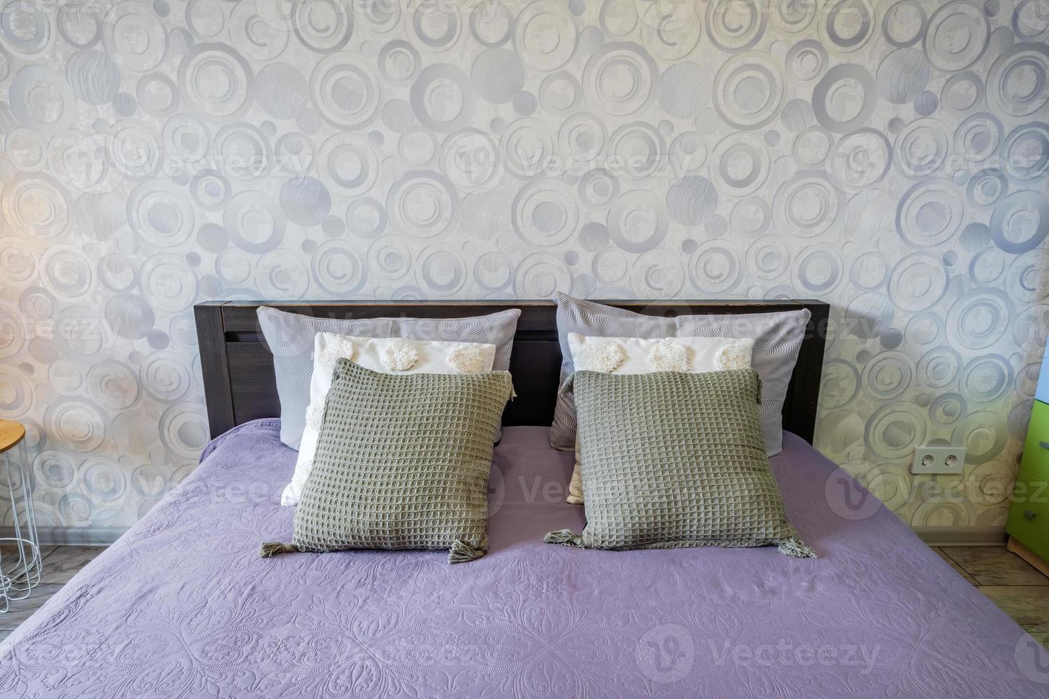 interior of the modern luxure bedroom in studio apartments in light color style with pillows and towels photo