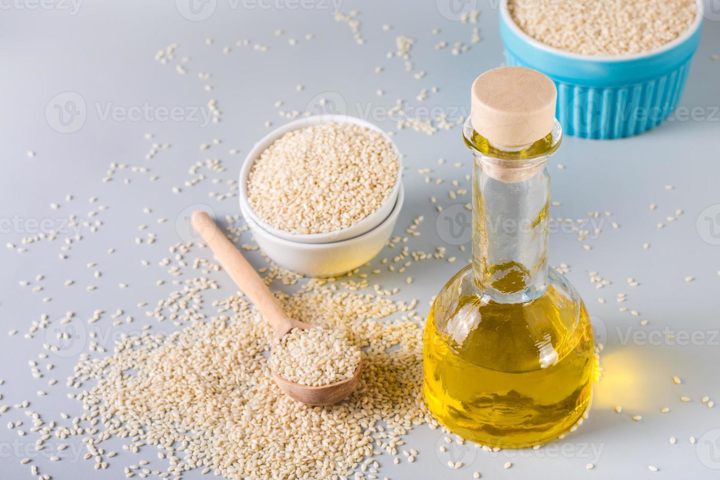 Sesame oil in a glass and seeds in a bowl on the table. Organic Alternative Food photo