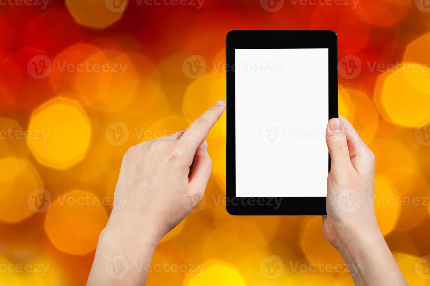 hand with tablet pc on dark red blurred background photo