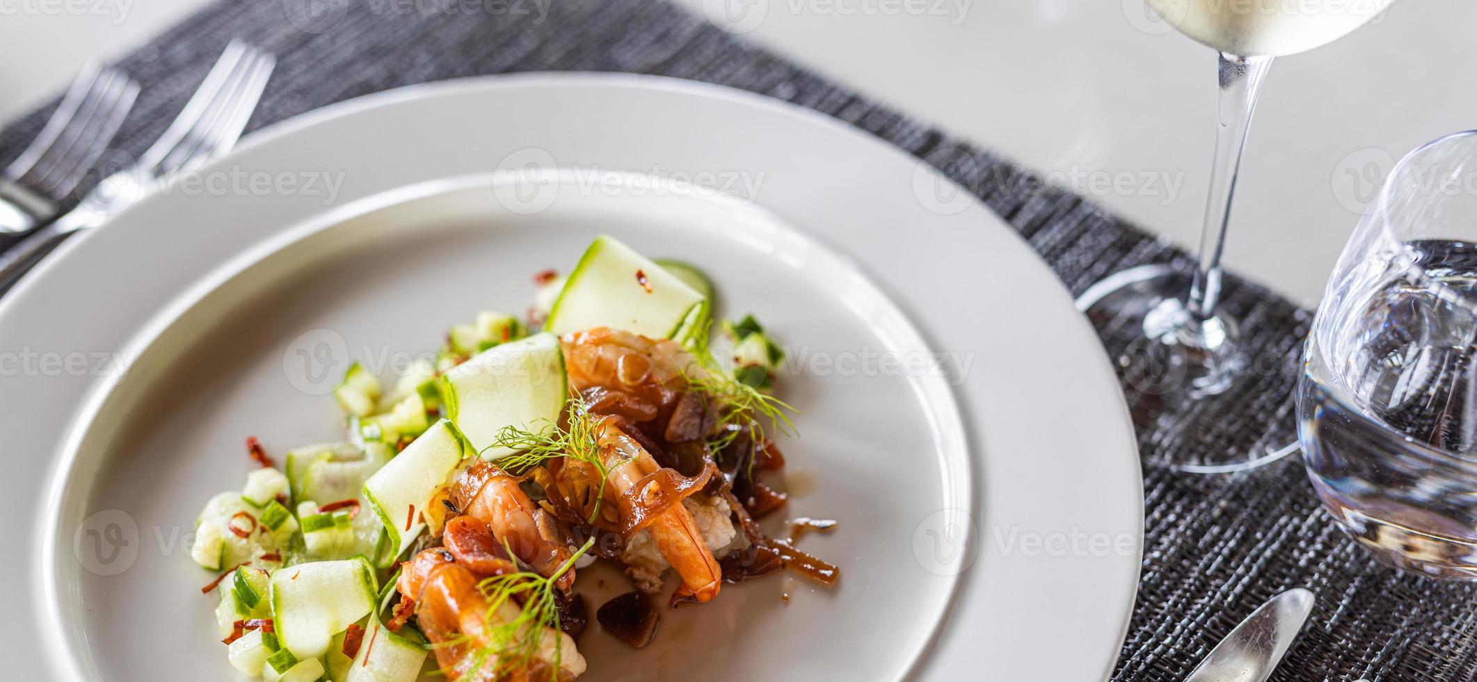 Luxury gourmet appetizer of cucumber rolls with shrimps and closeup vegetables on elegant white plate. horizontal table top, white wine. Cuisine luxurious dinner salad, appetizer meal photo