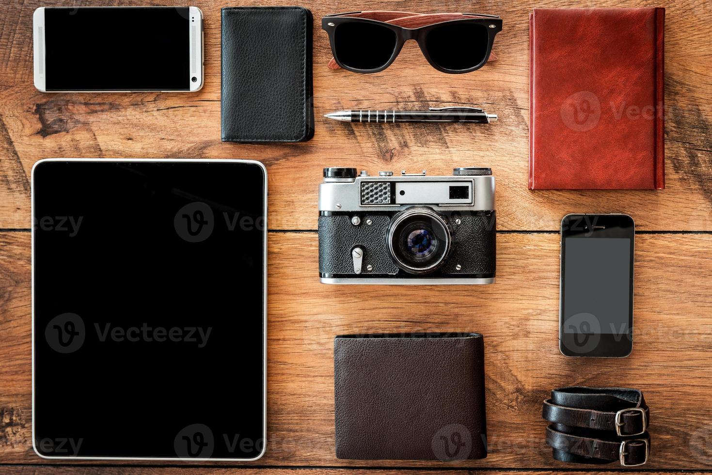 Interaction of retro and modern. Top view of diverse personal accessory laying on the wooden grain photo