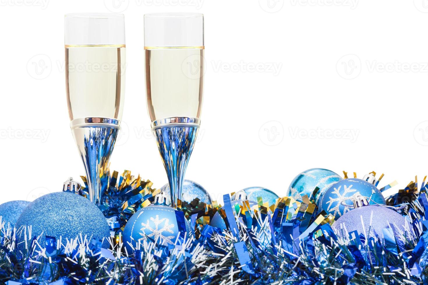 dos copas de vino espumoso y adorno navideño azul foto