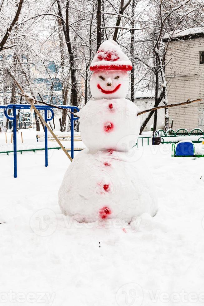snowman at public urban yard in winter day photo