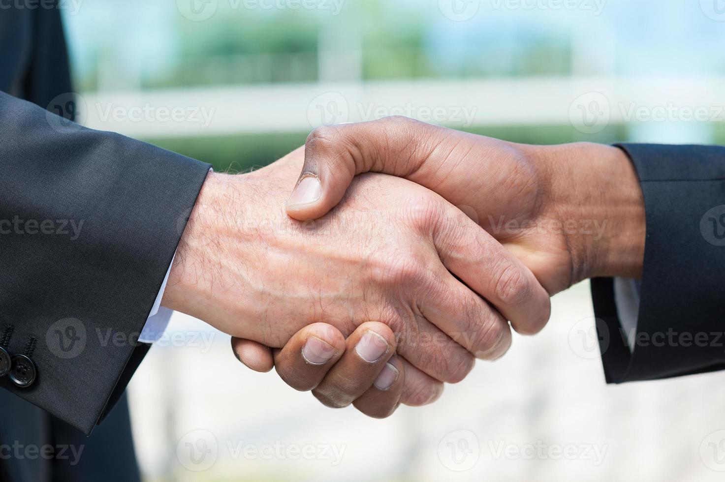 apretón de manos de negocios. primer plano de hombres de negocios dándose la mano foto