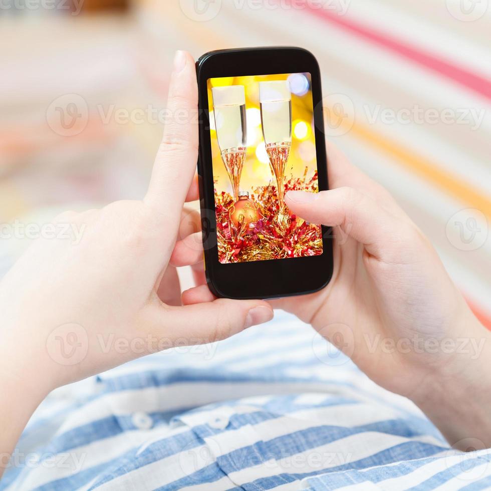 woman touches smartphone with gold Xmas still life photo