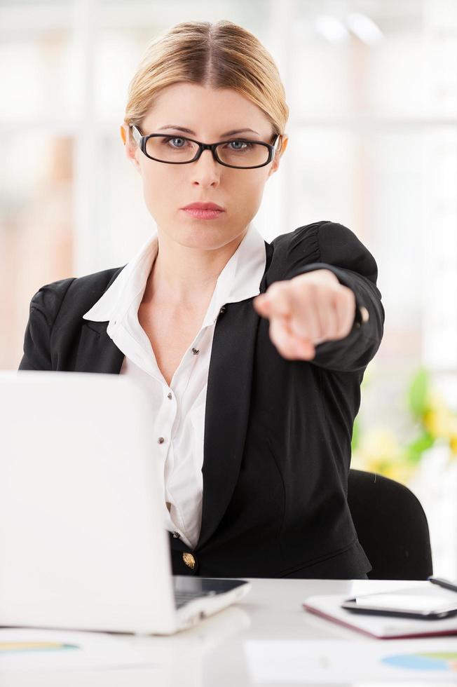 Rejection. Serious mature woman in formalwear saying no to you while stretching out a paper photo