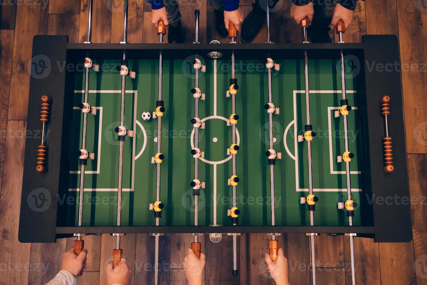 Foosball game. Top view of foosball table on the wooden floor photo