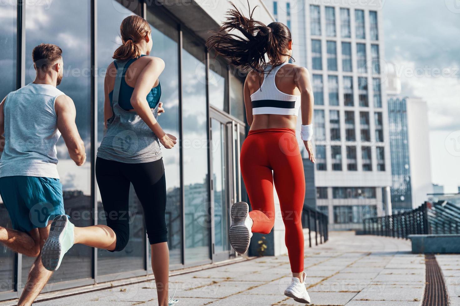 vista trasera de personas con ropa deportiva corriendo mientras