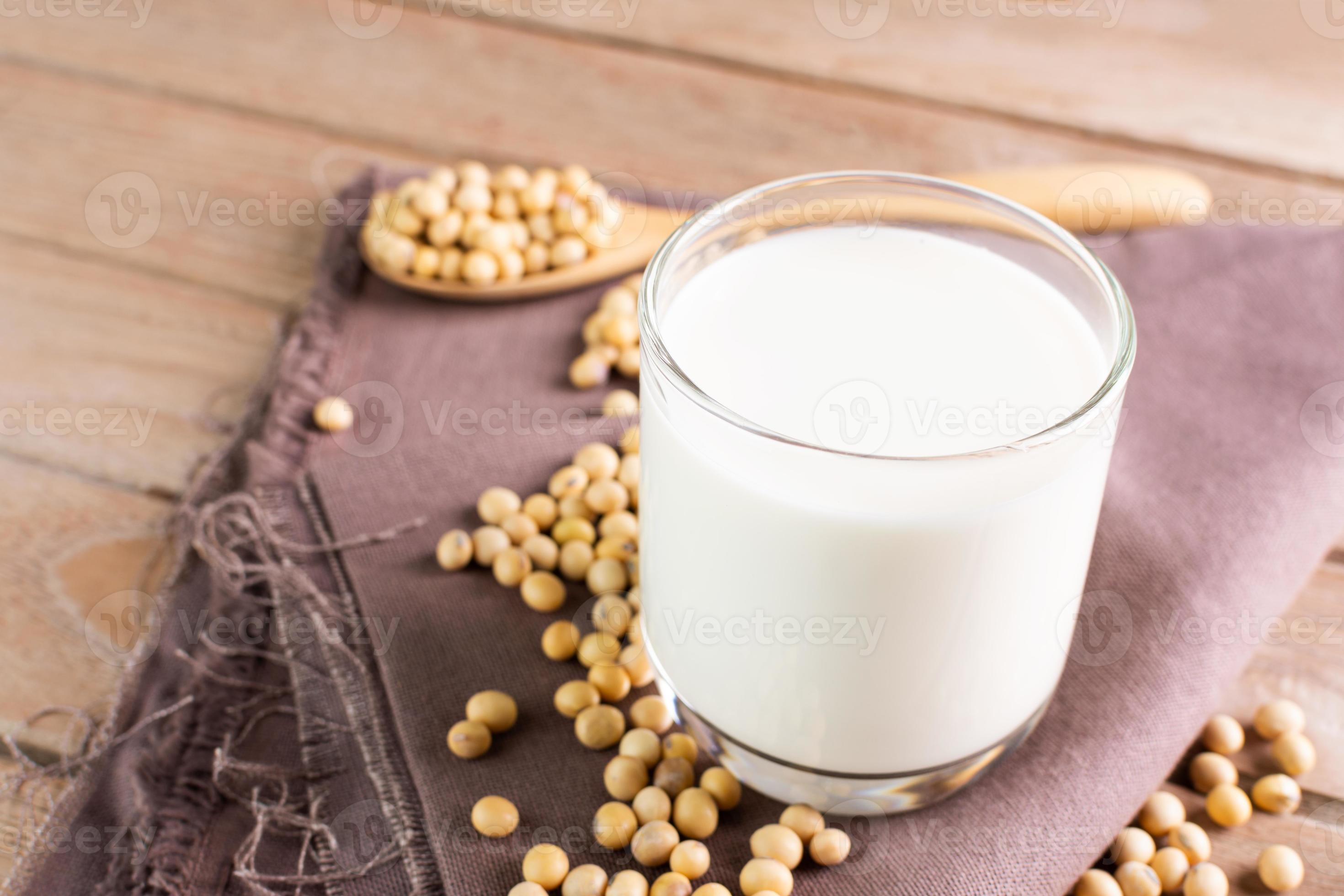 Soy milk in a glass with soybeans on a wooden table organic drink high
