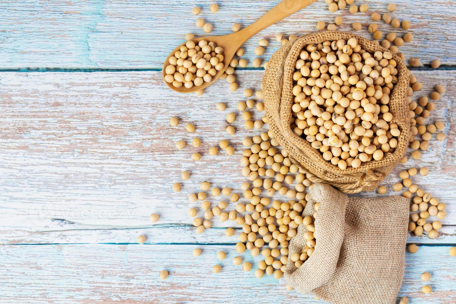 Soybeans in bags lying on wooden tables, rustic atmosphere. Concept. Protein, fat, healthy food. Agricultural products - top view photo