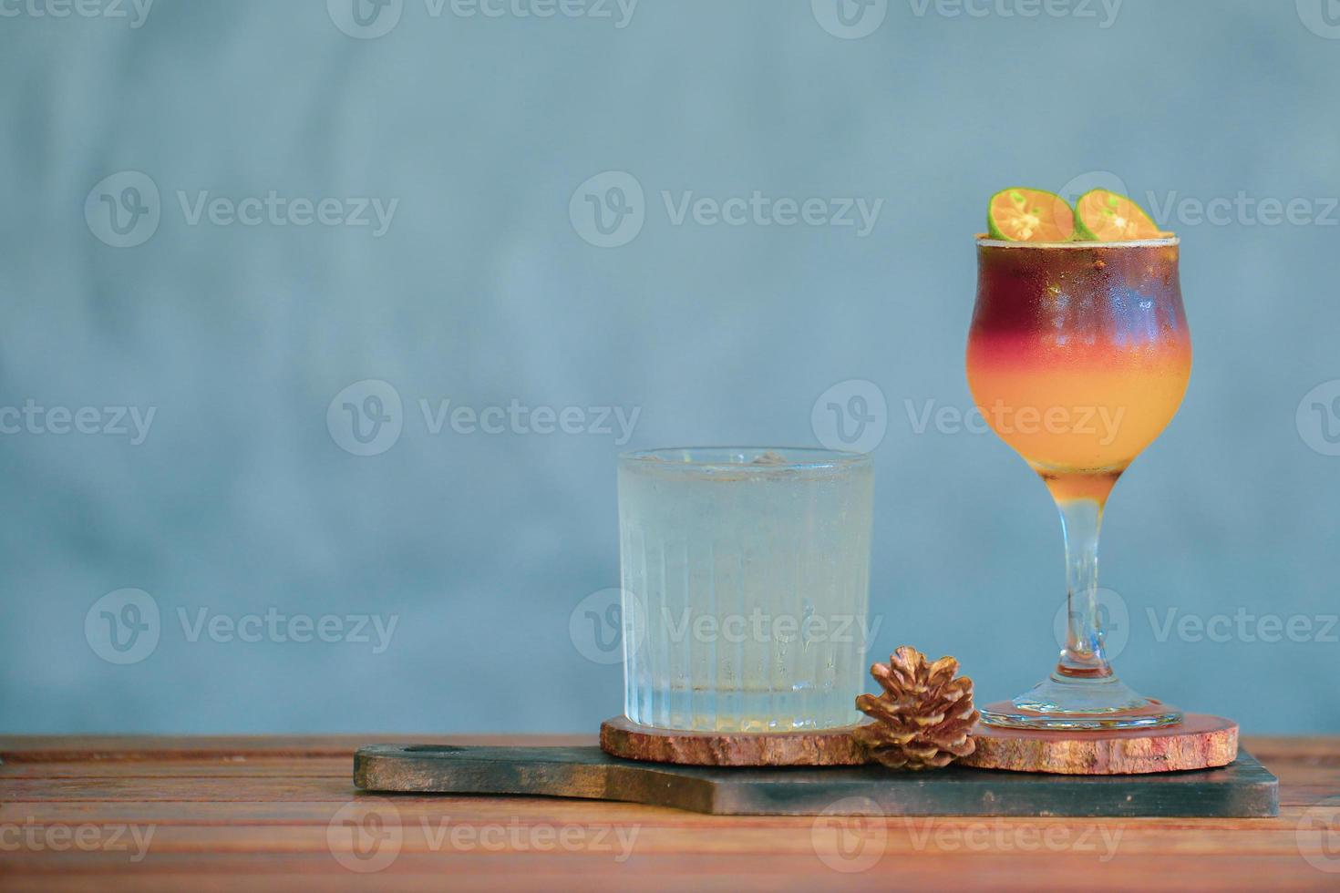 bebida refrescante café y zumo de naranja en la misma taza. café mezclado con jugo de naranja con hielo para enfriar en un hermoso vaso. foto