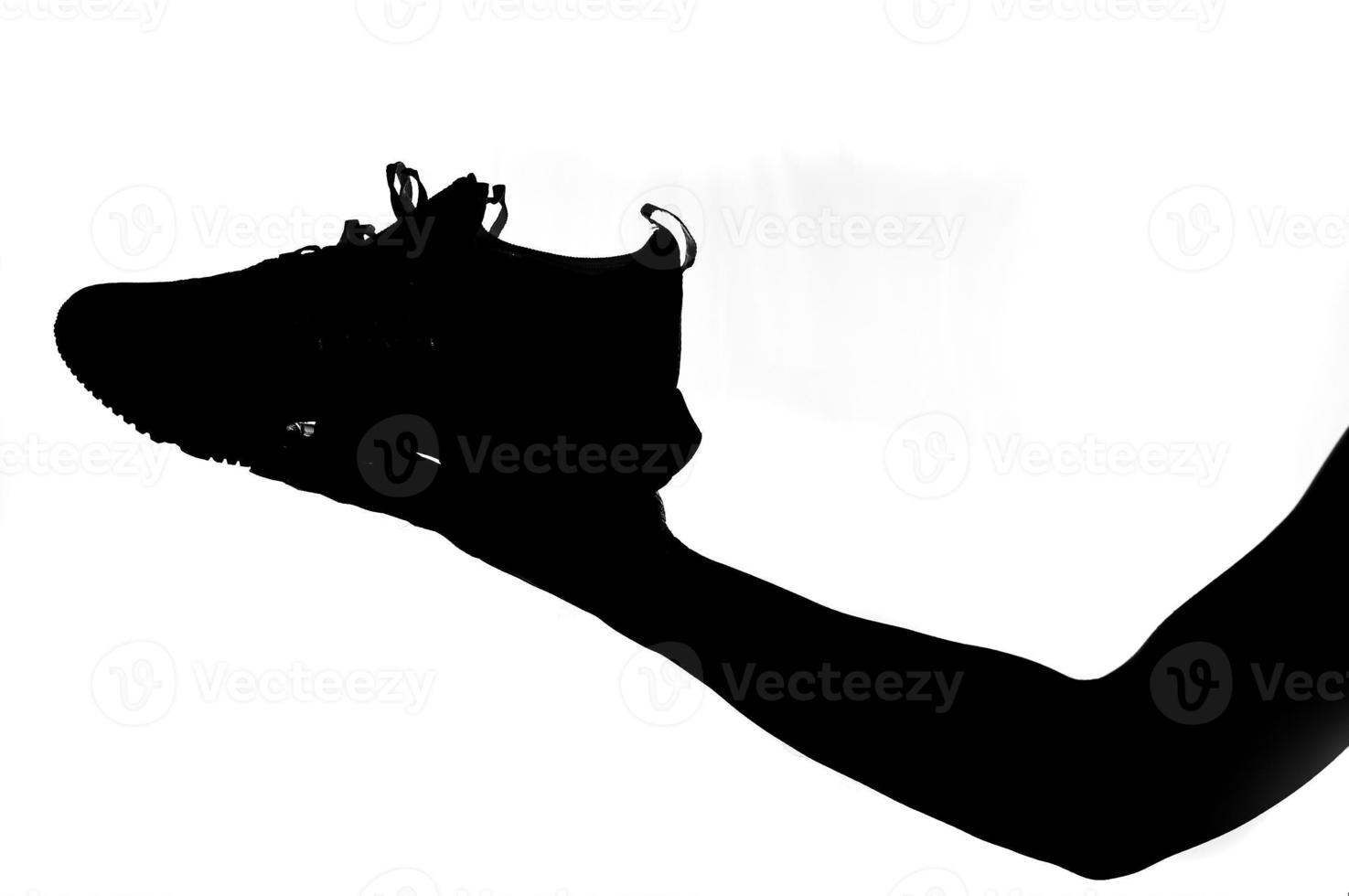 man's hand holding a running shoe on a white background. Ideas for buying running shoes and exercise. photo