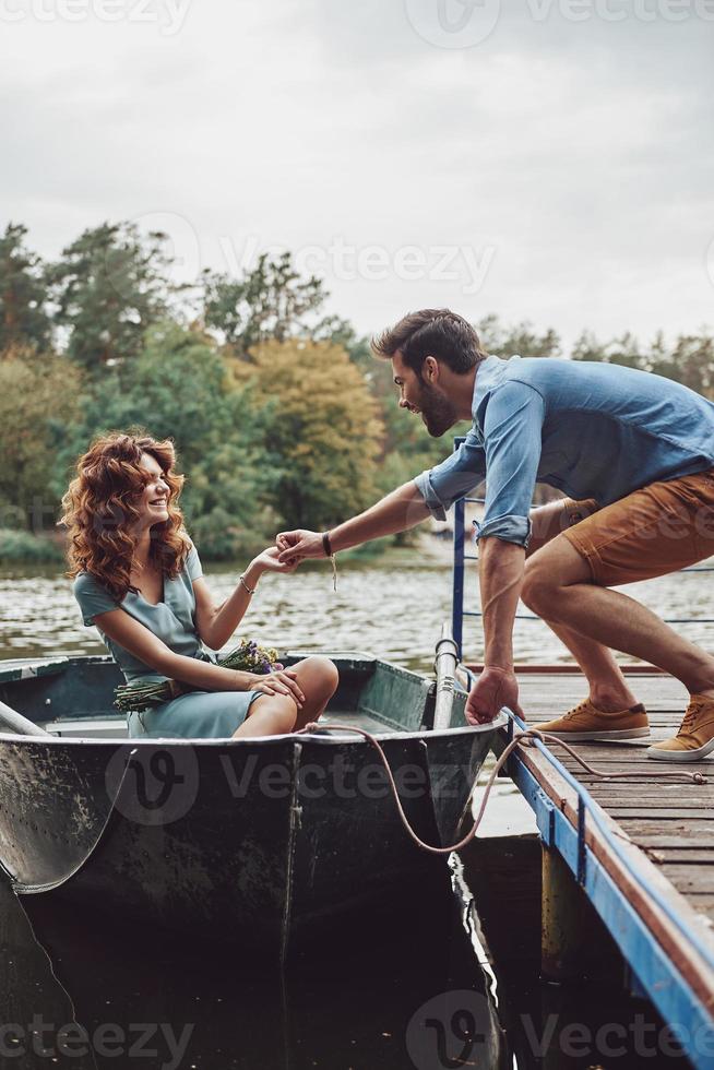 Best way to spend the date. Happy young couple getting ready to row a boat while enjoying their date outdoors photo