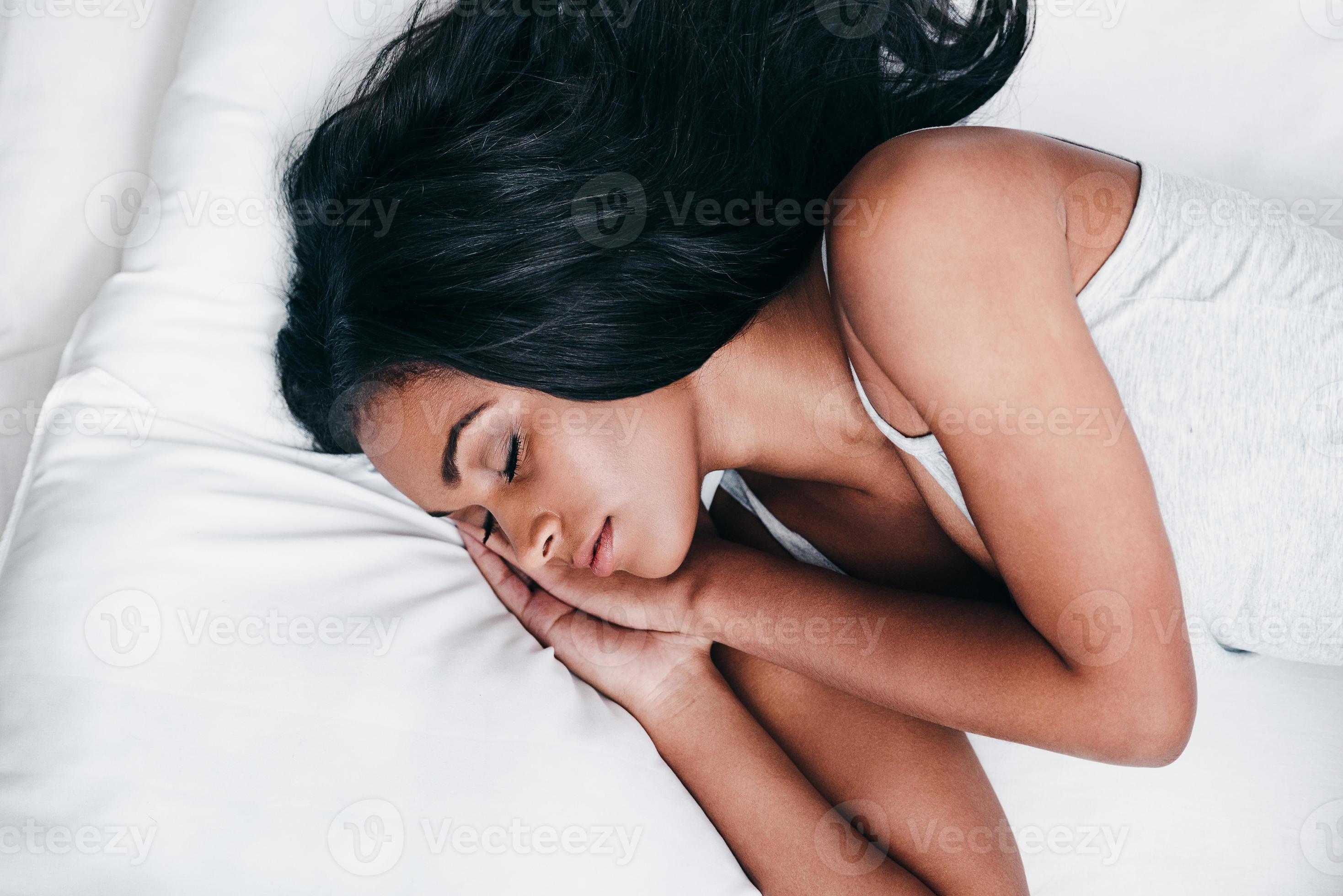 Beauty in bed. Top view close-up of beautiful young African woman in black  lingerie lying in bed and looking at camera 13576603 Stock Photo at Vecteezy