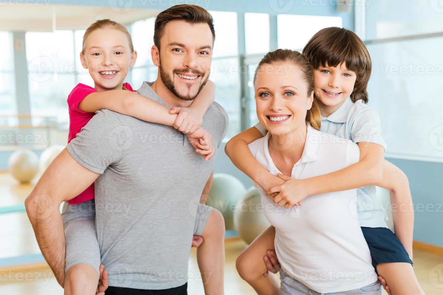 Sporty family. Happy sporty family bonding to each other while standing in sports club together photo