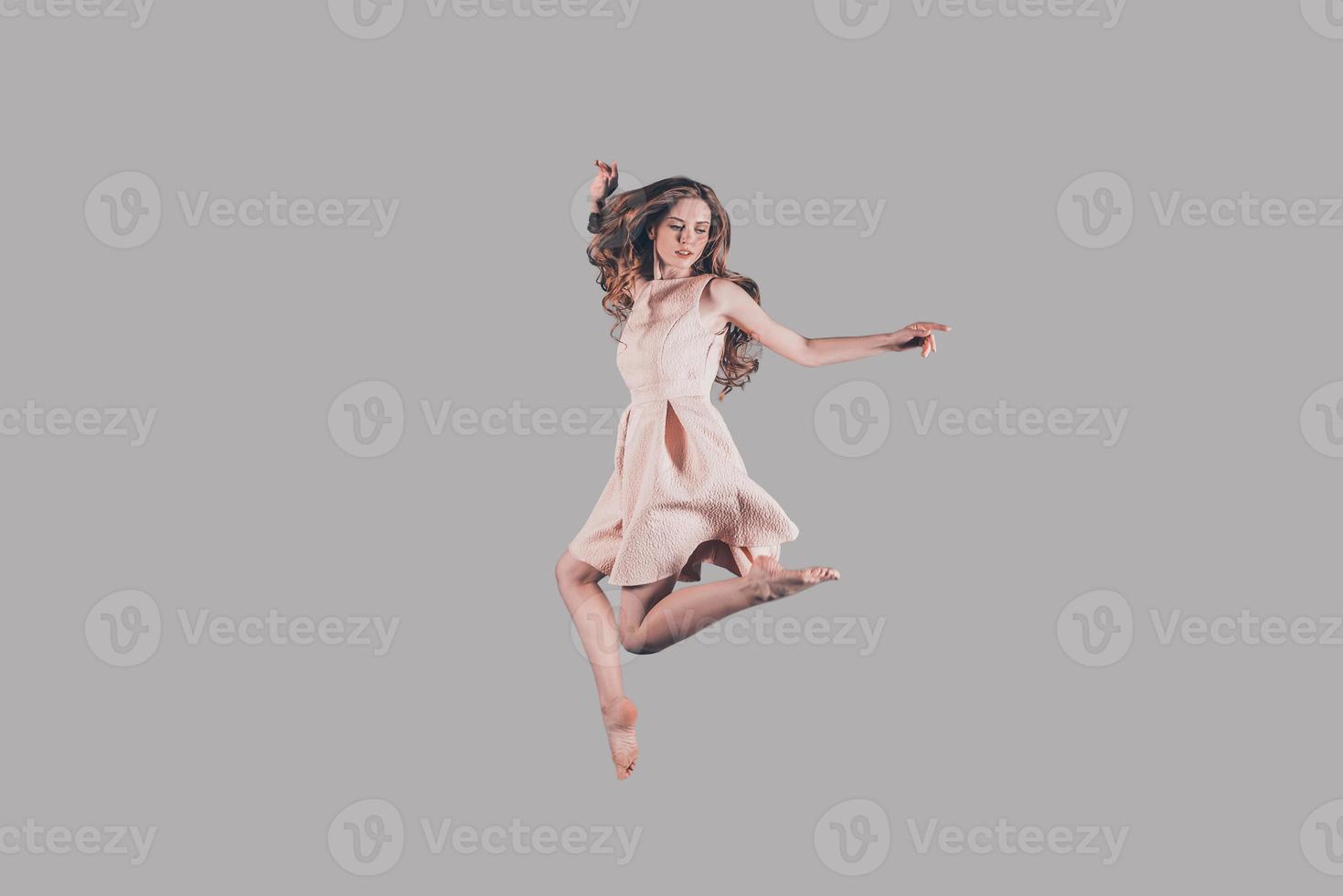 Levitation. Studio shot of attractive young woman hovering in air photo