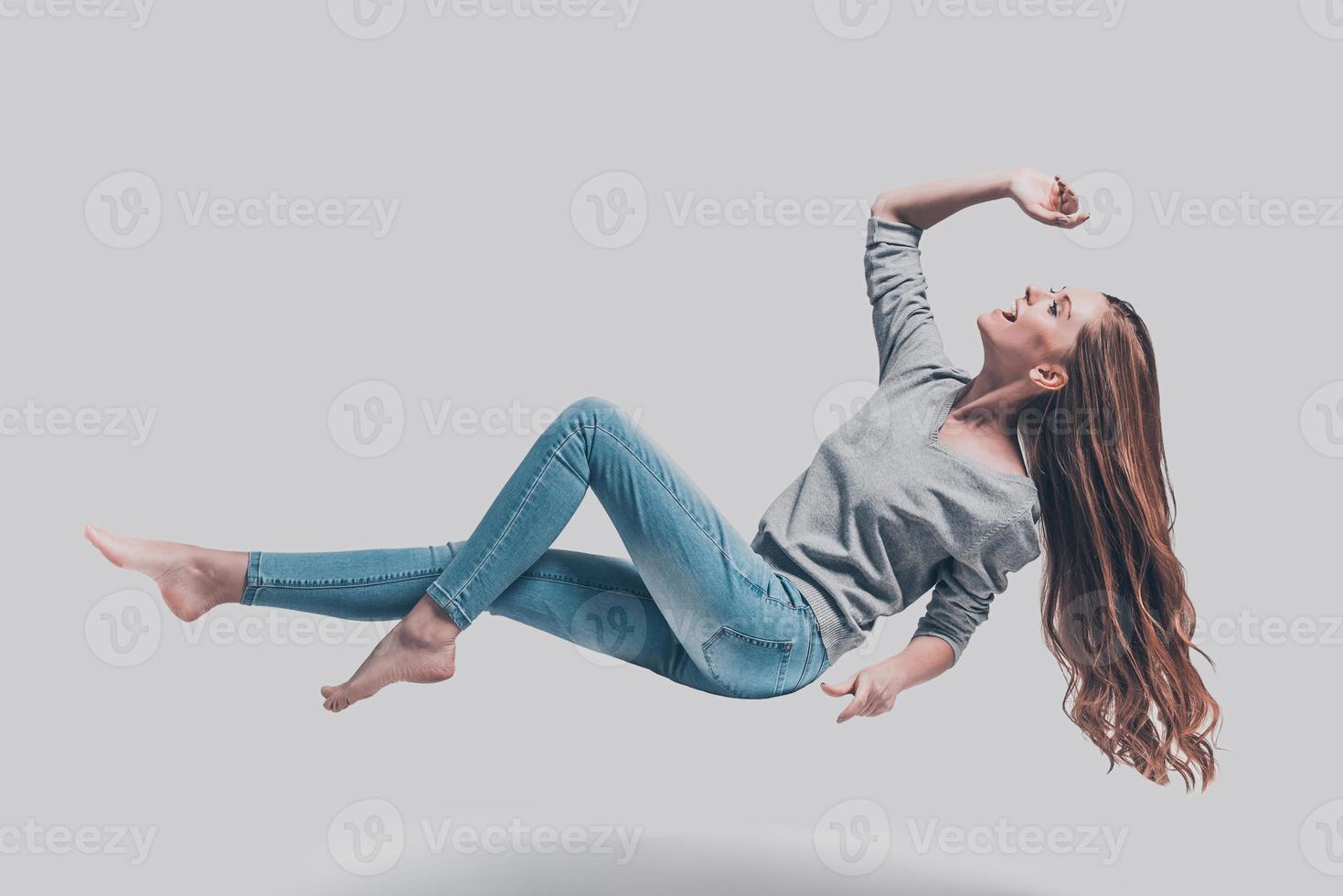 flotando en el aire. foto de estudio de longitud completa de una joven atractiva flotando en el aire y sonriendo