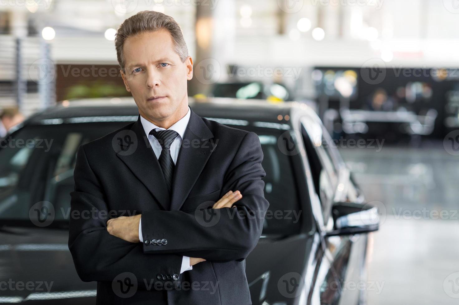 Confident in his choice. Mature grey hair man in formalwear standing in front of car and looking at camera photo