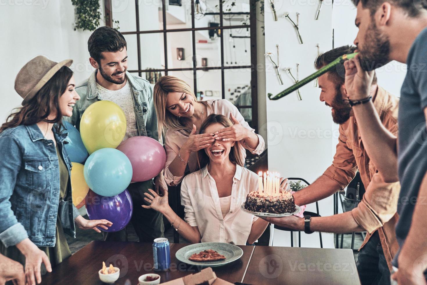 Time to make a wish. Group of happy people celebrating birthday among friends and smiling while having a dinner party photo