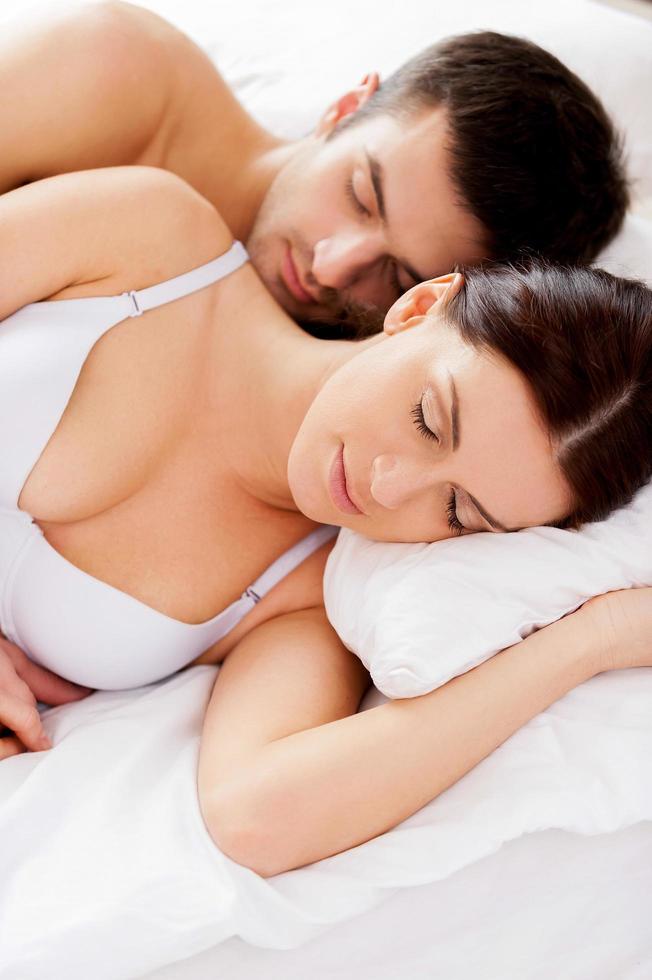 Sweet dreams. Top view of beautiful young loving couple sleeping together in bed photo