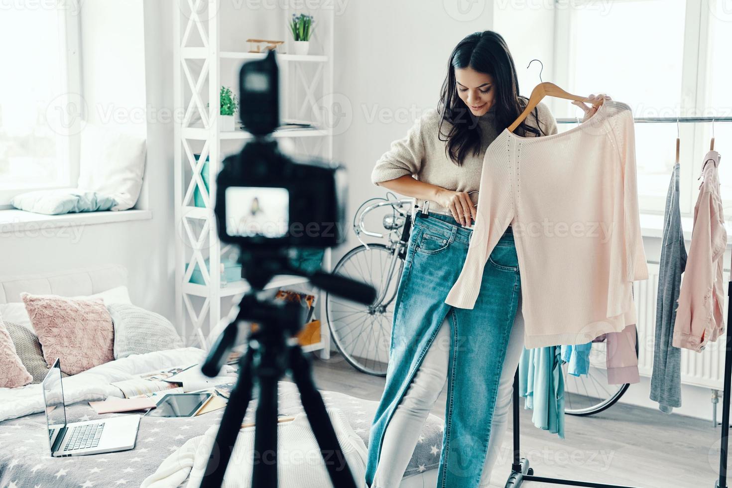 Beautiful young woman in casual clothing making social media video while spending time at home photo