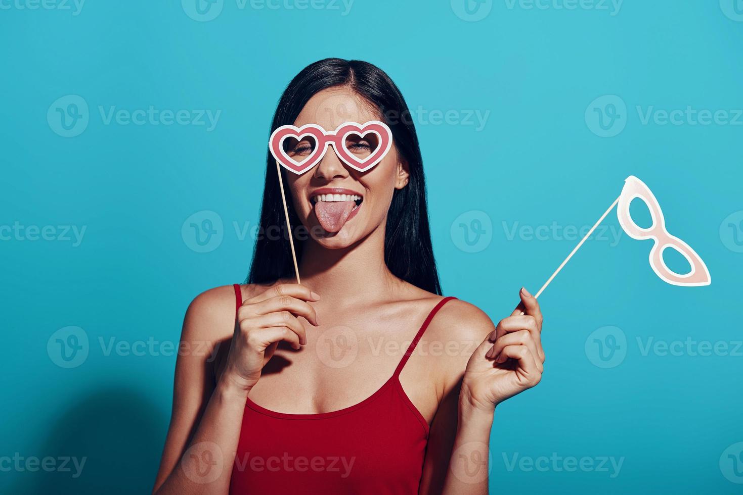 mujer joven atractiva sacando la lengua y usando una máscara para los ojos foto