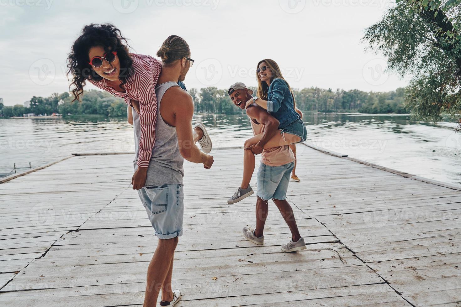 Joy of being in love. Beautiful young couples spending carefree time while standing on the pier photo