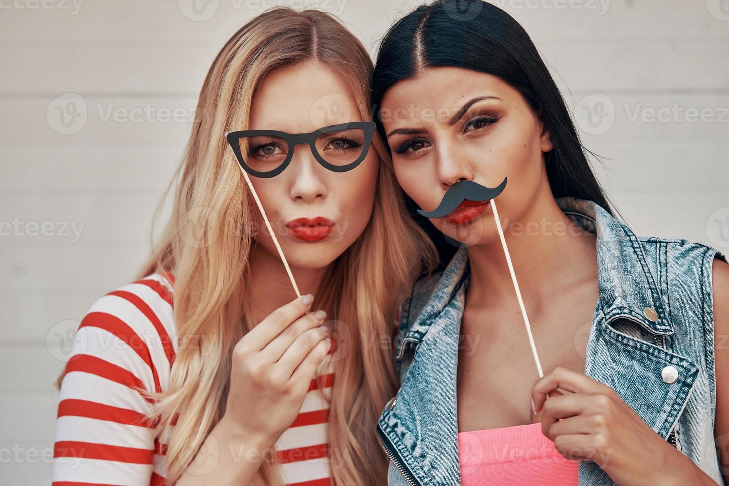 Making funny faces. Two playful young women making faces while standing outdoors photo