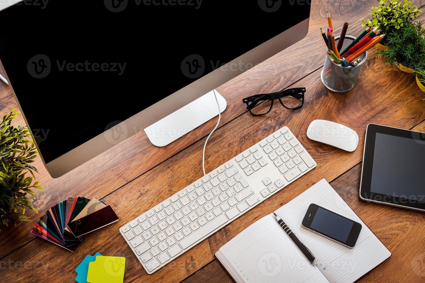 Comfortable working place.Top view ofcomfortable working place in office with wooden table and computer standing on it photo