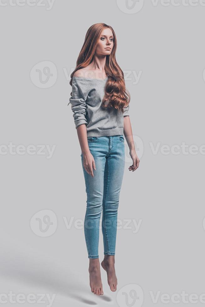 Mid-air motion. Mid-air shot of attractive young woman in casual wear photo