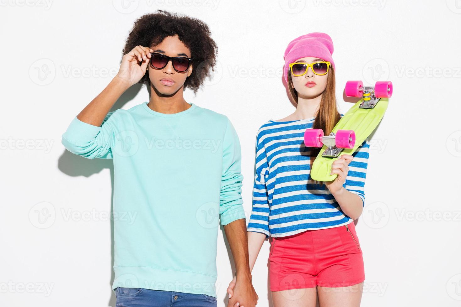 Super styling and in love. Funky young couple wearing eyewear and posing against white background photo