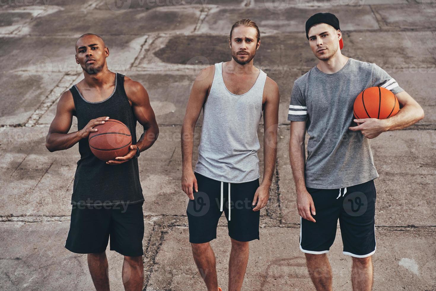 Ready to play Top view of young men in sports clothing looking at camera while standing outdoors photo