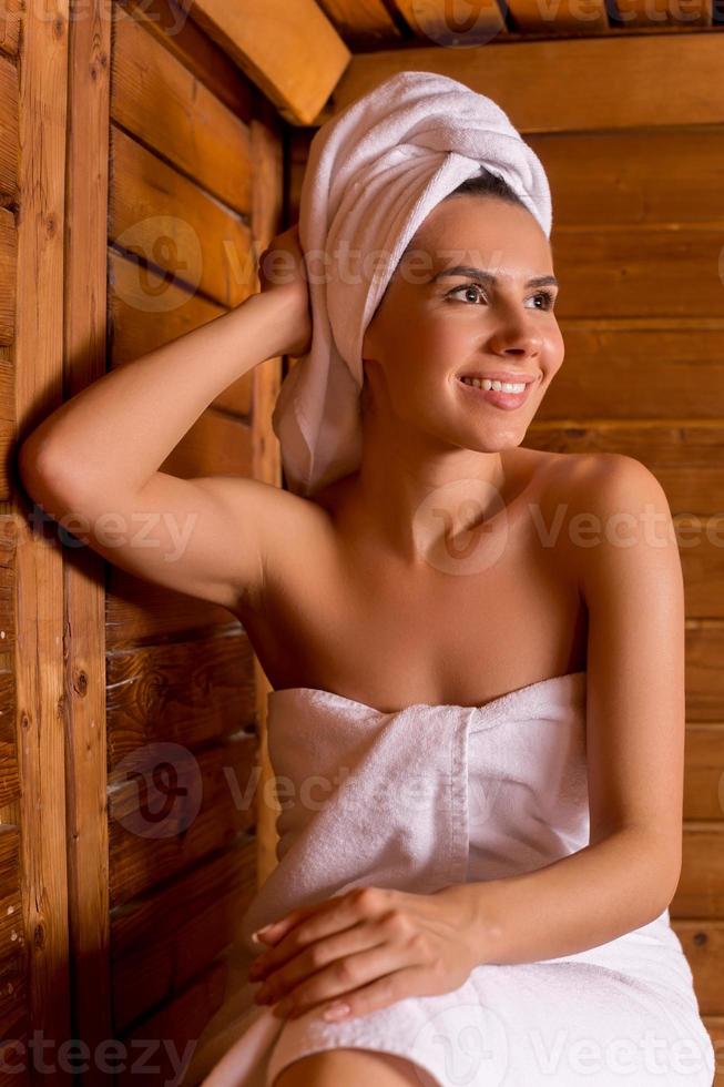 https://static.vecteezy.com/system/resources/previews/013/523/100/non_2x/beauty-in-sauna-beautiful-young-woman-wrapped-in-towel-relaxing-in-sauna-and-smiling-to-you-photo.JPG