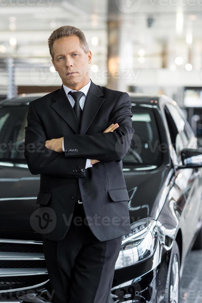 I choose only the best. Confident grey hair man in formalwear standing in front of car and looking at camera photo