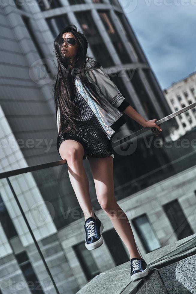 Beauty and style. Beautiful young woman in casual wear looking at camera while sitting outdoors photo