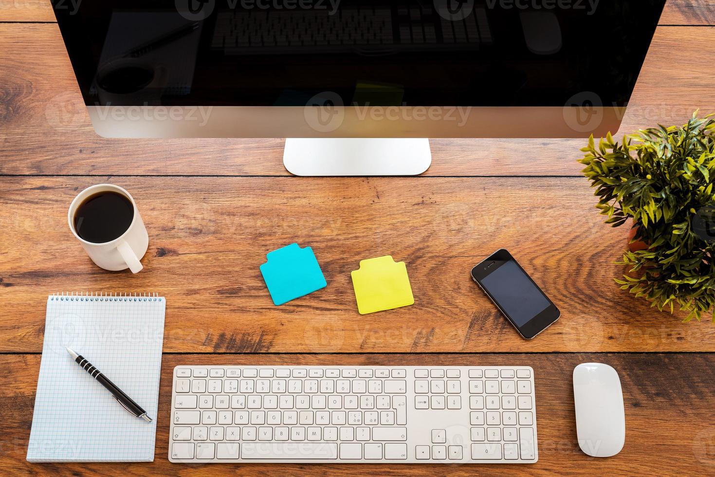 lugar de trabajo perfecto. vista superior del lugar de trabajo cómodo con mesa de madera y computadora de pie sobre él foto