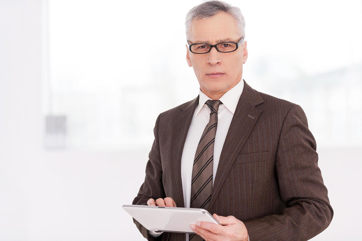 Businessman with digital tablet. Confident senior man in formalwear holding a digital tablet and looking at camera photo