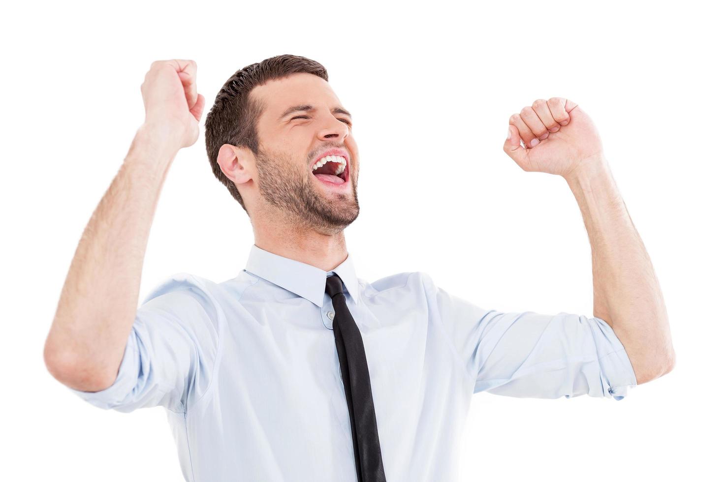 hombre de negocios feliz. joven feliz con camisa y corbata expresando positividad y gesticulando mientras está de pie aislado en blanco foto