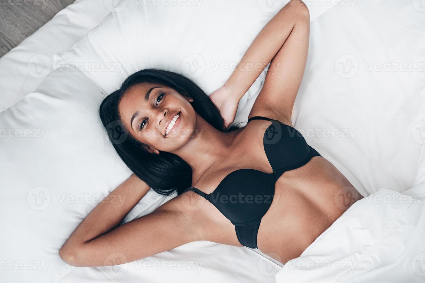 Good morning Top view of beautiful young African woman in black lingerie  lying in bed and looking at camera with smile 13525663 Stock Photo at  Vecteezy