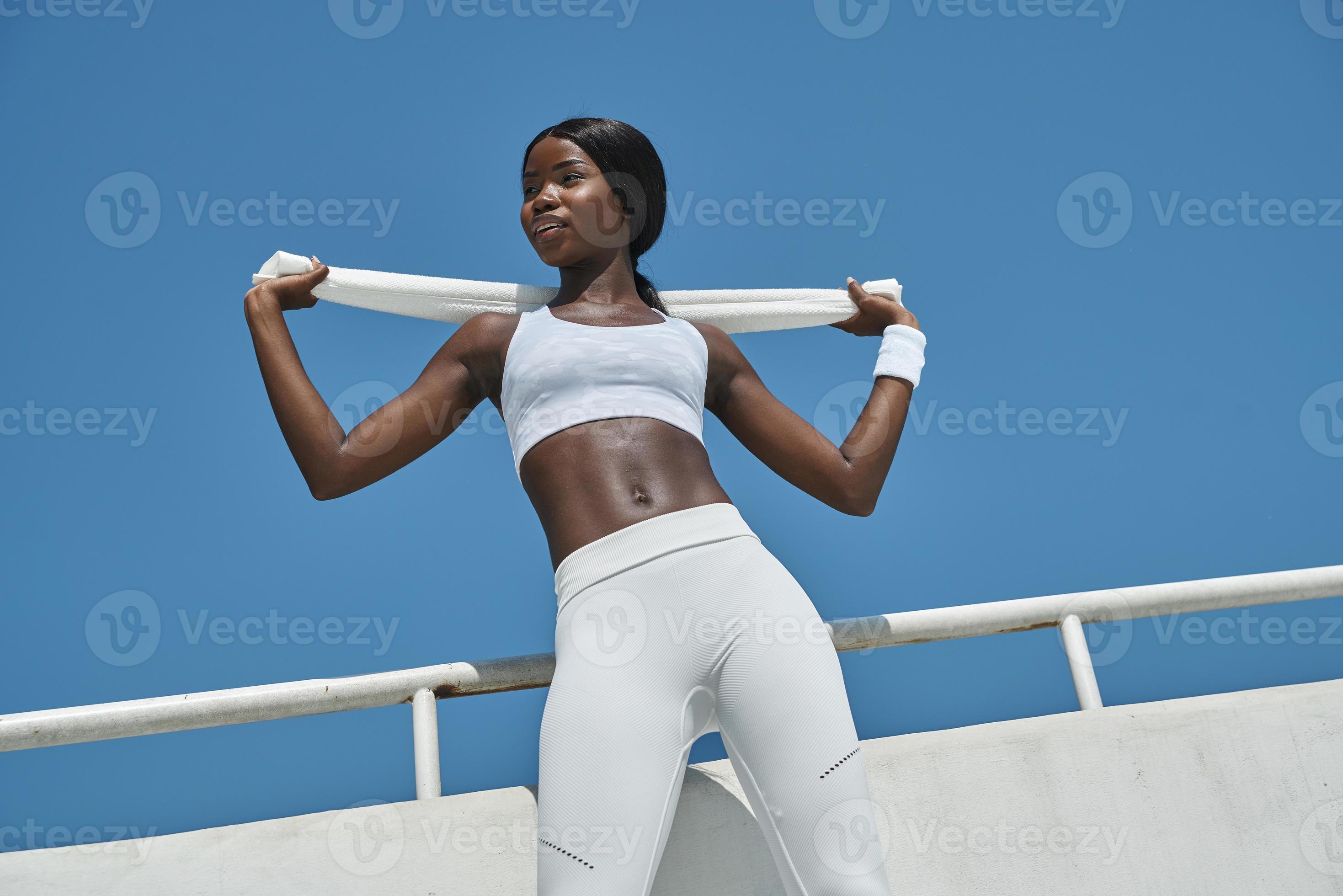 Low angle view of beautiful young African woman in sports clothing carrying  towel on shoulders 13525886 Stock Photo at Vecteezy